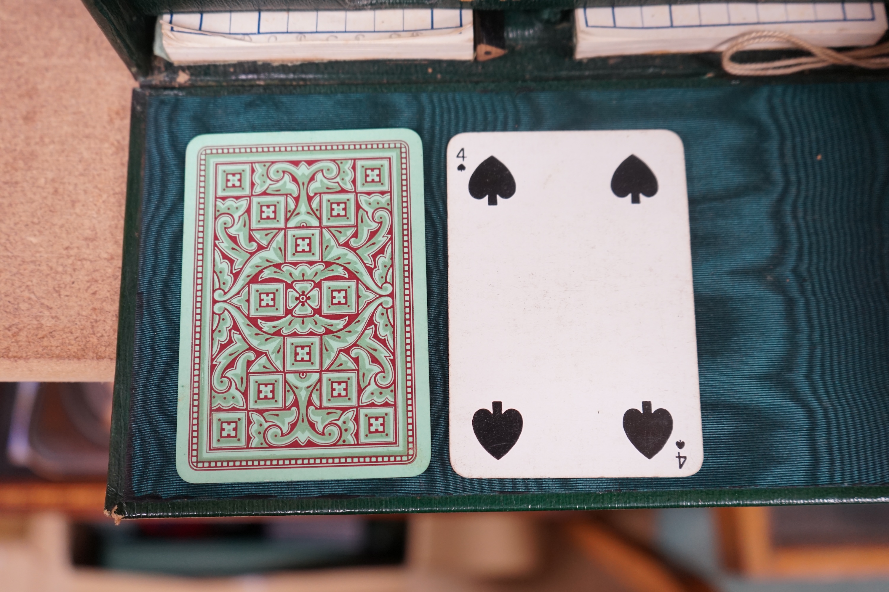 A Cook's patent stereoscope viewer and viewing cards together with a green Morocco leather playing cards box, box 12.5cm high x 24cm wide. Condition, games box poor, viewer and cards good